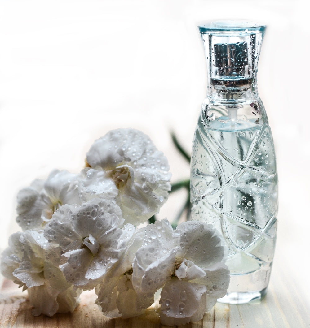 Perfume in bottle and fresh flowers